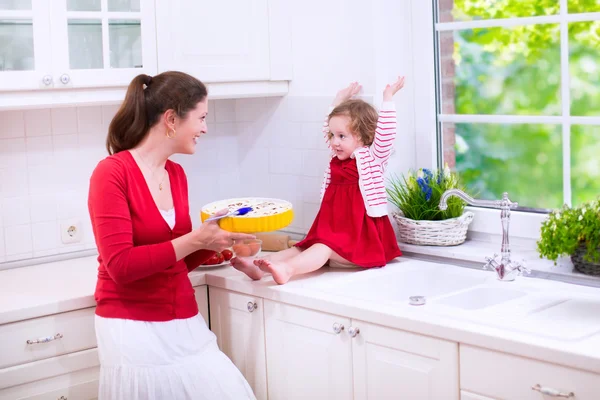 Genç anne ve kızı birlikte bir pasta pişirme — Stok fotoğraf