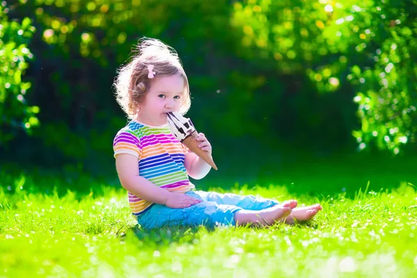Kleines Mädchen isst Eis im Garten — Stockfoto