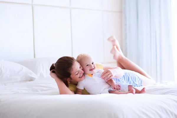 Mother and baby relaxing in white bedroom — Stok fotoğraf