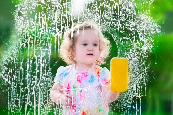 Menina lavando uma janela — Fotografia de Stock