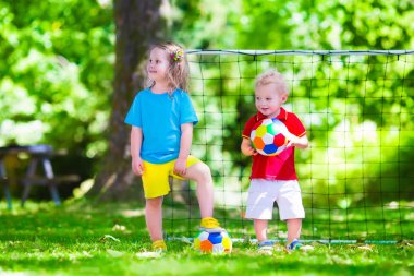 Çocuklar açık havada futbol oynarken