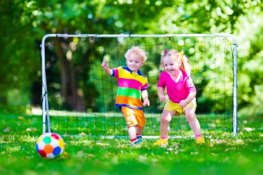 Okul bahçesinde futbol oynayan çocuklar