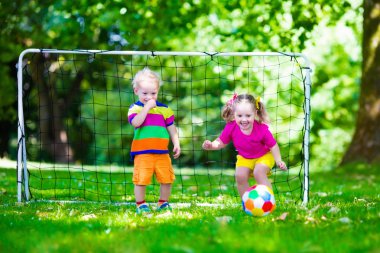 Okul bahçesinde futbol oynayan çocuklar