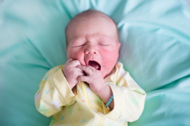 Newborn baby on a green blanket
