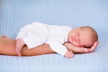 Little baby boy sleeping in arms of his father