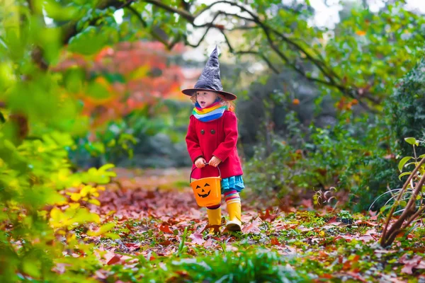 Klein meisje in een heks kostuum op Halloween — Stockfoto