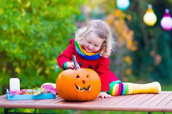 Little girl carving pumpkin at Halloween — Stockfoto