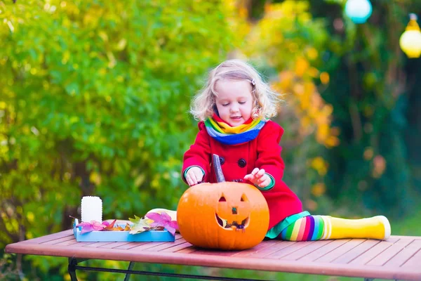 Маленька дівчинка ріже гарбуз на Хеллоуїн — стокове фото