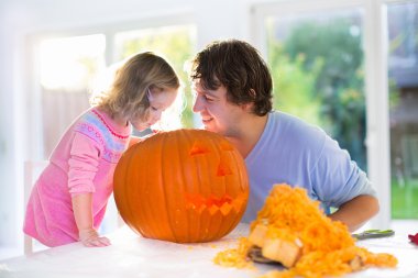 Father and child carving pumpkin for Halloween