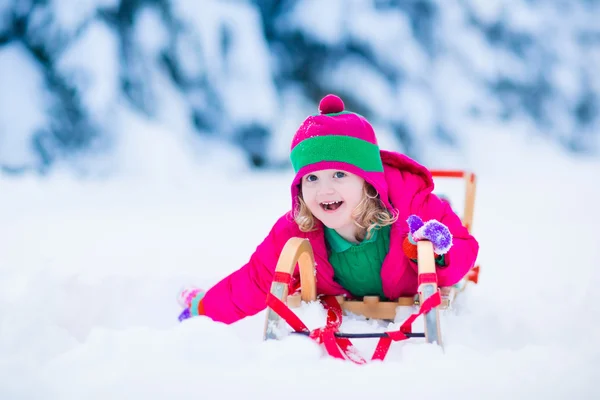 Little girl enjoying a sleigh ride in winter — Stock Photo, Image
