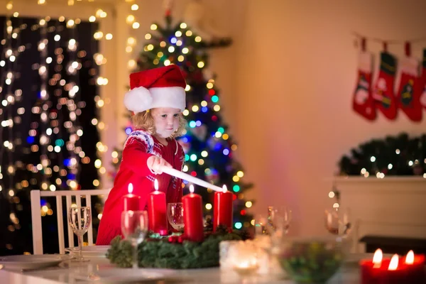 クリスマスのディナーで少女照明キャンドル — ストック写真