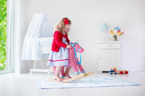 Dziewczynka na koniu zabawka — Zdjęcie stockowe