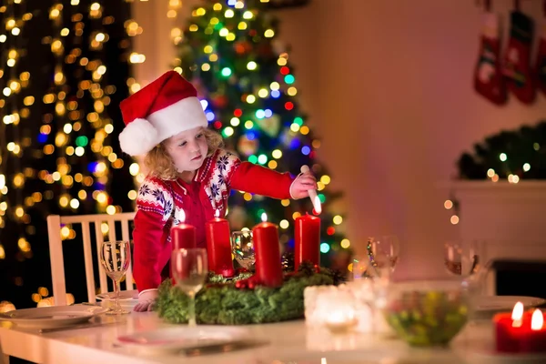 Kleines Mädchen zündet Kerzen beim Weihnachtsessen an — Stockfoto