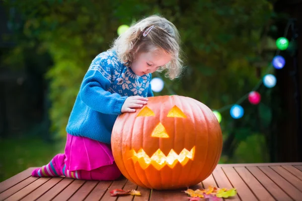 Little girl carving pumpkin at Halloween — Stockfoto