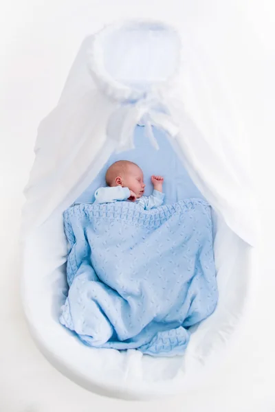Newborn baby boy in white bassinet — Stockfoto