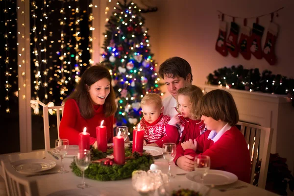 Семья устраивает рождественский ужин у камина Стоковая Картинка