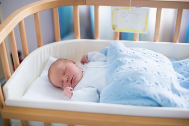 Newborn baby boy in hospital cot