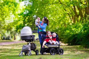 Mother with three children in buggy and stroller