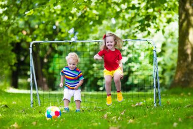 Okul bahçesinde futbol oynayan çocuklar
