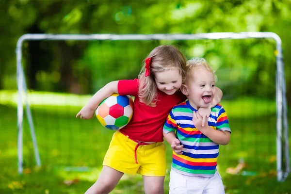 Дети играют в футбол в парке — стоковое фото