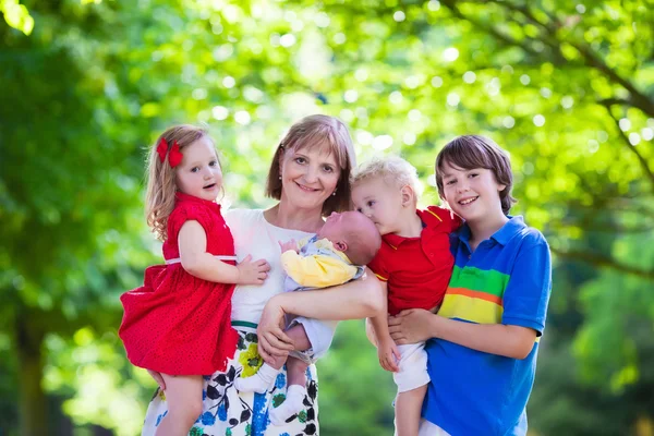 Porträt einer glücklichen Frau mit vier Kindern — Stockfoto