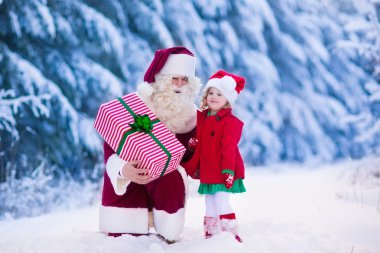 Noel Baba karlı parkta küçük kız konuşuyor