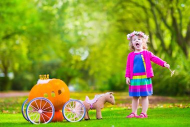 Little girl at pumpkin patch at Halloween