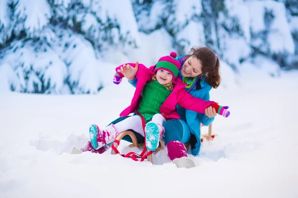 Μητέρα και παιδί με έλκηθρο σε ένα χιονισμένο πάρκο — Φωτογραφία Αρχείου
