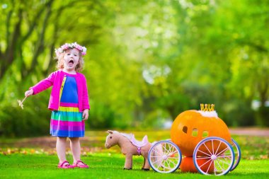 Little girl at pumpkin patch at Halloween
