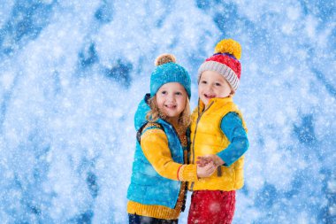 Çocuklar kışın dışarıda oynuyorlar.