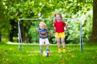 Okul bahçesinde futbol oynayan çocuklar
