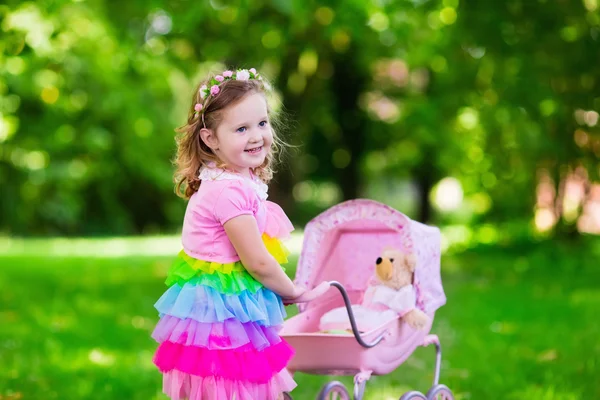 Menina empurrando um brinquedo stoller wth doll — Fotografia de Stock