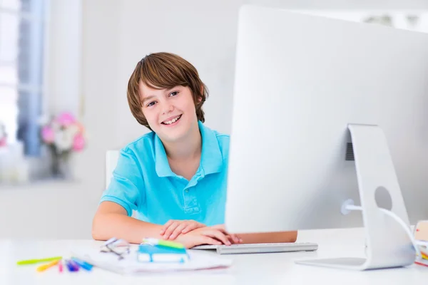 Menino fazendo lição de casa com computador moderno — Fotografia de Stock