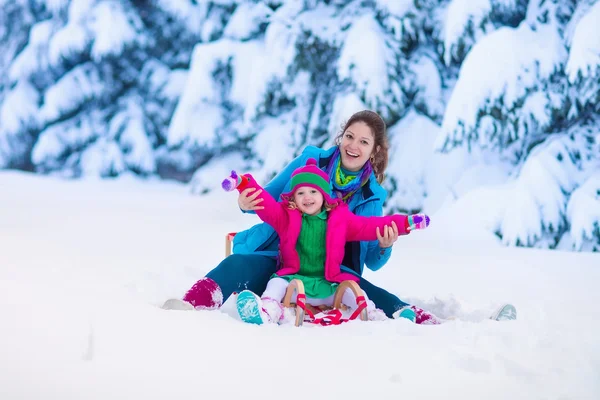 Madre e hijo en trineo en un parque cubierto de nieve —  Fotos de Stock