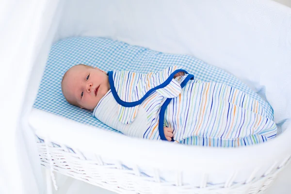 Lite swaddled baby i vit säng — Stockfoto