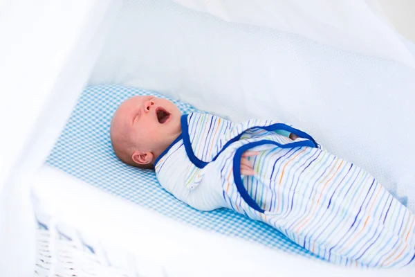 Lite swaddled baby i vit säng — Stockfoto