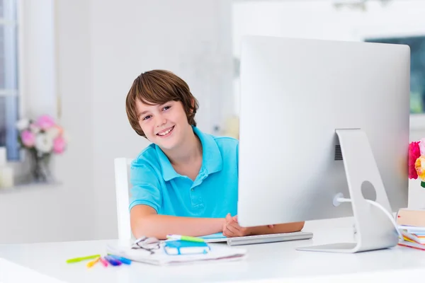 Menino fazendo lição de casa com computador moderno — Fotografia de Stock