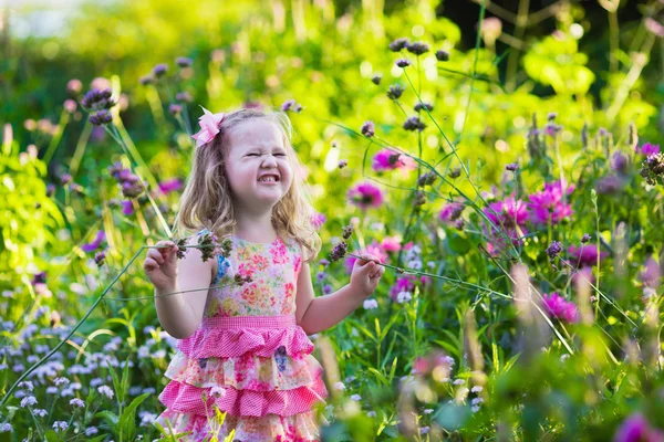 Little girl in flower garden — Stock Photo, Image