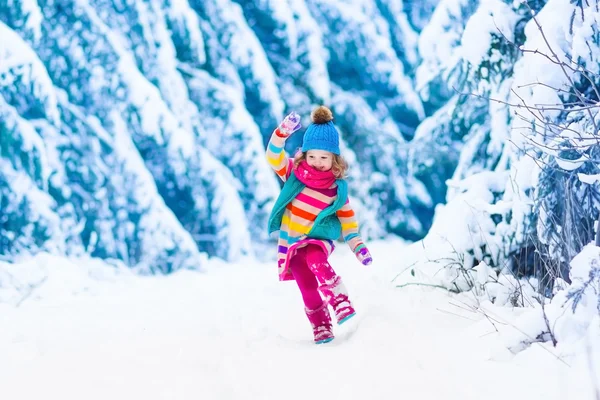 Little girl playing in snowy winter forest — Stock Photo, Image