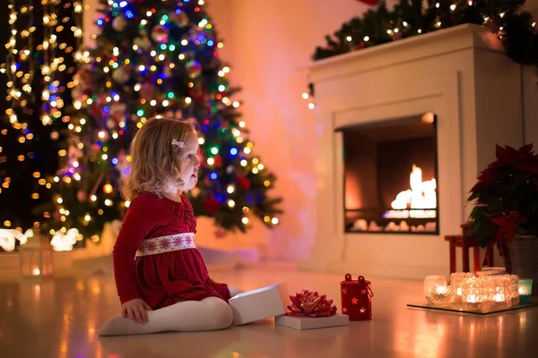 Enfants ouvrant cadeaux de Noël à la cheminée — Photo