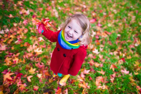 Niña jugando con hoja de arce en otoño — Foto de Stock