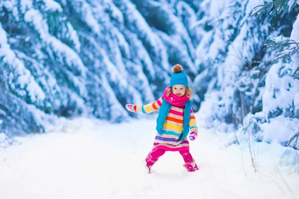 Menina brincando na floresta de inverno nevado — Fotografia de Stock