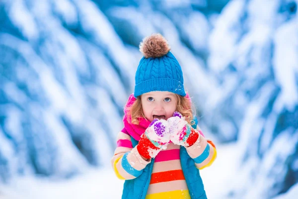 雪に覆われた冬の森で遊ぶ少女 — ストック写真