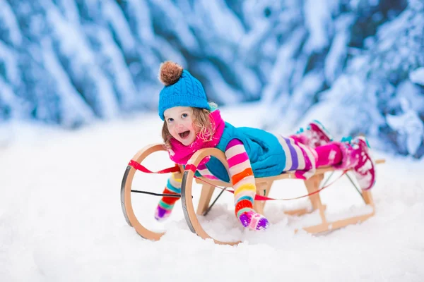 Kleines Mädchen spielt im verschneiten Winterwald — Stockfoto