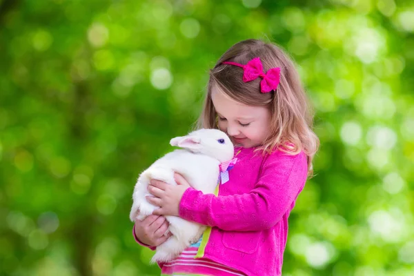 Little girl playing with rabbit