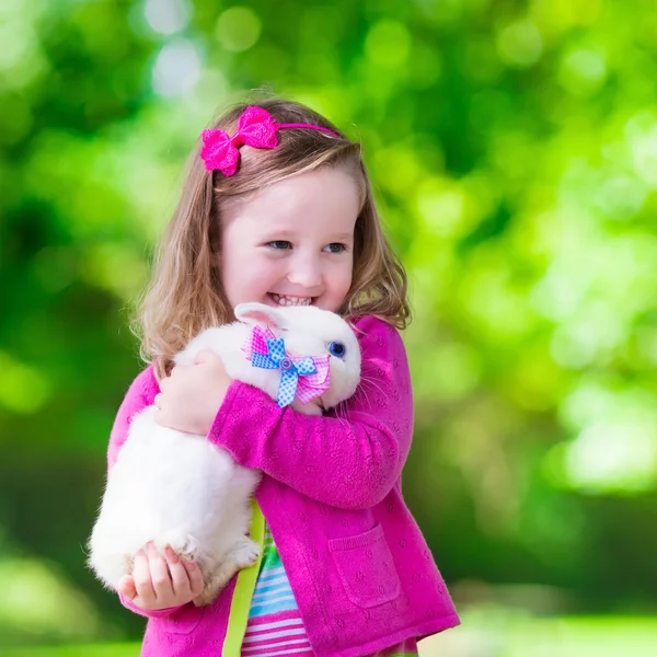 Little girl playing with rabbit — Stock Photo, Image