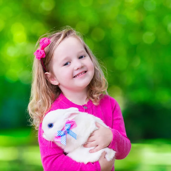 Kleines Mädchen spielt mit Kaninchen — Stockfoto