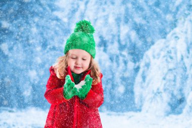 Karlı parkta oynarken küçük kız