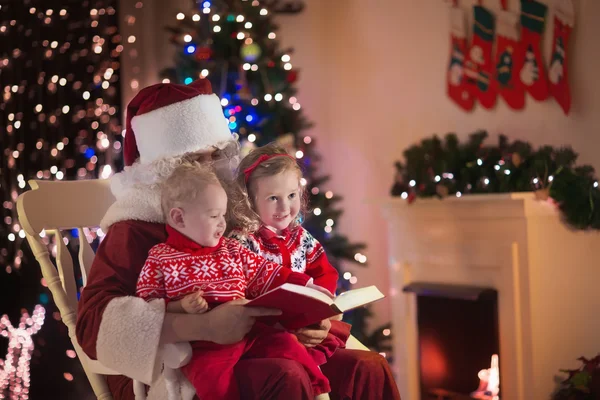 Kids and Santa at fire place on Christmas eve — стокове фото