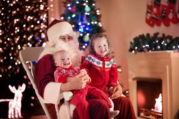 Kids and Santa at fire place on Christmas eve — Zdjęcie stockowe